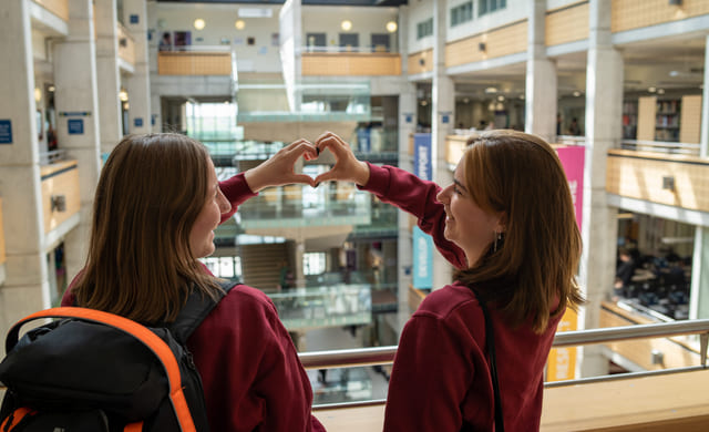 To elever lager et hjerte med hendene på York College i England