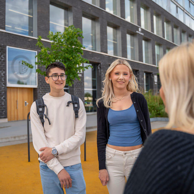 Elever står utenfor Akademiet VGS Fredrikstad.