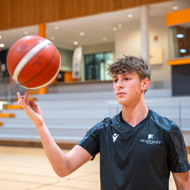 Elev spinner basketballen på fingeren