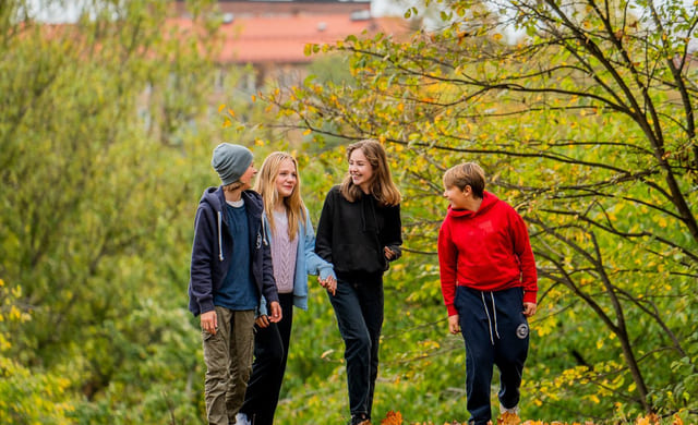 Elever på Akademiet Realfagsskole Oslo går i høstløvet utenfor skolen