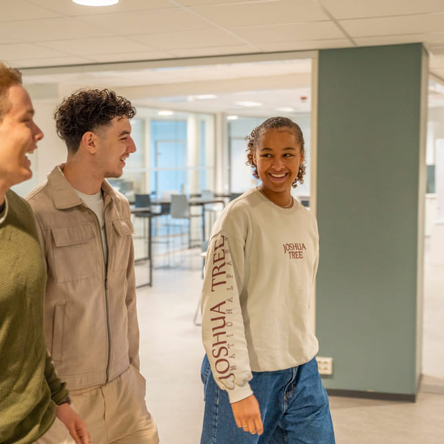 Tre elever på Akademiet VGS Heltberg Ullevaal går bortover gangen.