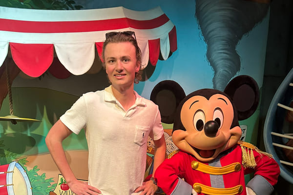 Carl poserer ved siden av Minnie Mus i Disneyland.