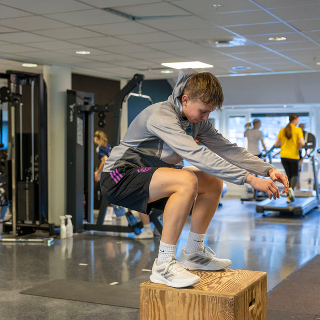 Elev trener styrke i et treningsstudio på Akademiet